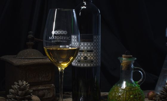 Bottle and glass of Matošević wine in a rustic still life setting