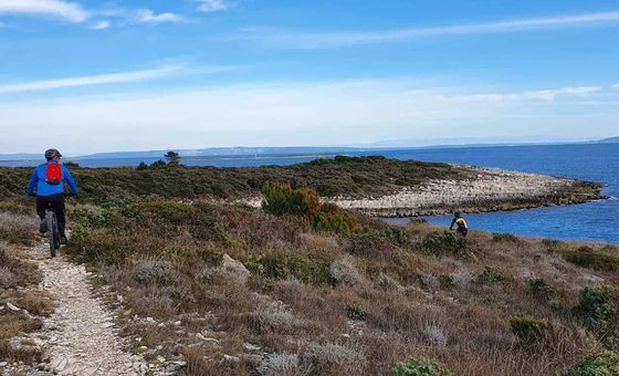 Mountain bikers exploring rugged seaside trails on the Kamenjak Peninsula near Premantura, Istria